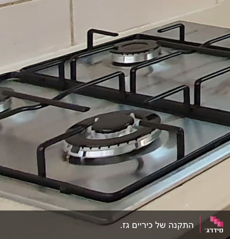 כיריים גז עם ארבעה מבערים וכפתורי שליטה